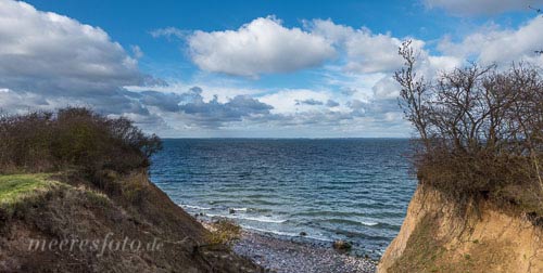 Ein tiefer Abbruch in der Brodtener Steilküste gibt den Blick frei auf die Wellen und den Horizont der Ostsee