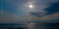  Segeln bei Nacht auf dem Fehmarnsund –  DETAIL: Das Bild zeigt ein Segelboot bei nächtlicher Fahrt im Mondlicht zwischen den Stränden bei der Ortschaft Fehmarnsund und dem Campingplatz Miramar auf der Insel Fehmarn und Großenbrode.