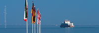  Eine Fähre auf der Nordsee und Flaggen auf einer Seebrücke vor Wyk auf Föhr