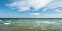 Sanfte Ostseewellen und markante Wolkenformation vor Haffkrug