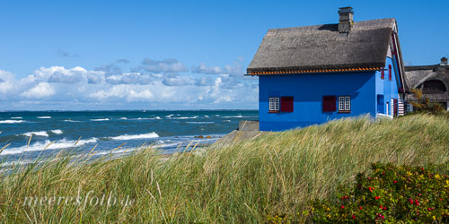 Ein blaues Haus am sonnigen Ostseestrand von Graswarder bei Heiligenhafen