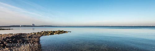 Eine Steinbuhne am Strand von Niendorf und das Maritim am Horizont