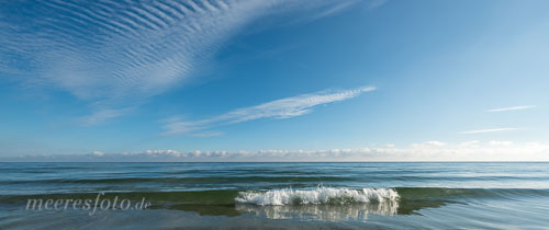 Ein kleiner Wellenkamm unter einem blauen Himmel mit Cirrocummulus-Wolken vor dem Strand von Sehlendorf