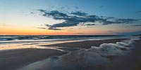  Wolken spiegeln sich nach Sonnenuntergang in einem Priel am Strand von Wenningstedt