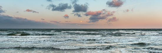 Der Vollmond über dem Horizont an einem stürmischen Tag an der Ostsee am Timmendorfer Strand