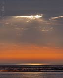  »Sonnenstrahl am Morgen über dem Watt bei Amrum – 2« DETAIL: Niedrigwasser vor der Ostseite der Insel Amrum. Das morgendliche Sonnenlicht bahnt sich, durch einen Riss in der Wolkendecke, einen Weg auf das Watt.