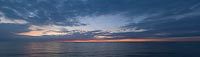  Kurz vor Nacht am Fehmarnbelt –  DETAIL: Das letzte Glühen der Sonne am Horizont der Ostsee. Der Blick von Puttgarden Richtung Rødby. Am Horizont ist ein beleuchtetes Fährschiffe zu sehen.
