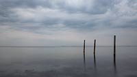  Drei Pfähle in der Ostsee vor Graswader –  DETAIL: Dieses sehr farbreduzierte Foto, zeigt drei Holzphäle vor dem Strand von Graswader. Im Hintergrund erkennt man die Südwest-Spitze von Fehmarn.