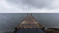  Holzsteg an der Dockkoogspitze in Husum mit Blick auf Nordstrand an einem wolkigen und regnerischen Sommermorgen