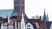  Petrikirche mit hanseatischen Fassaden an der Untertrave –  DETAIL: Ein Blick auf die Altstadt von Lübeck. Durch den engen Ausschnitt des Fotos, wirkt die Petrikirche sehr dominant. Im Hintergrund zeigt das Bild noch die Kuppel der Propsteikirche Herz Jesu und eine Kuppel des Lübecker Doms.