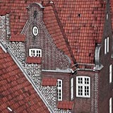  Lübeck deine Ziegel 1 –  DETAIL: Ein Bild aus der Serie »Lübeck deine Ziegel« aus dem Jahre 2004. Die Fotos zeigen Aufnahmen von Lübeck aus einer erhöhten Perspektive – Dachziegel, Ziegelsteine und weiße Fensterrahmen. Harte Kontraste und eine markante Farbigkeit heben die besondere Art der hanseatischen Architektur hervor.