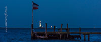  Ein Bootssteg mit einer zerschlissenen Schleswig-Holstein-Flagge im Wind bei Nacht in der Kieler Förde